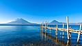 Wooden pier at Lake Atitlan on the beach in Panajachel, Guatemala. With beautiful landscape scenery of volcanoes Toliman, Atitlan and San Pedro in the background.