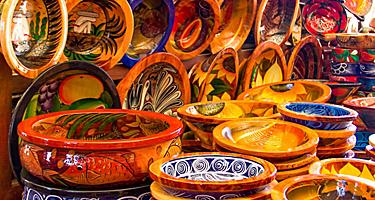 Mexican pottery in bold earthy colors and patterns at artisan market in Puerto Vallarta, Mexico