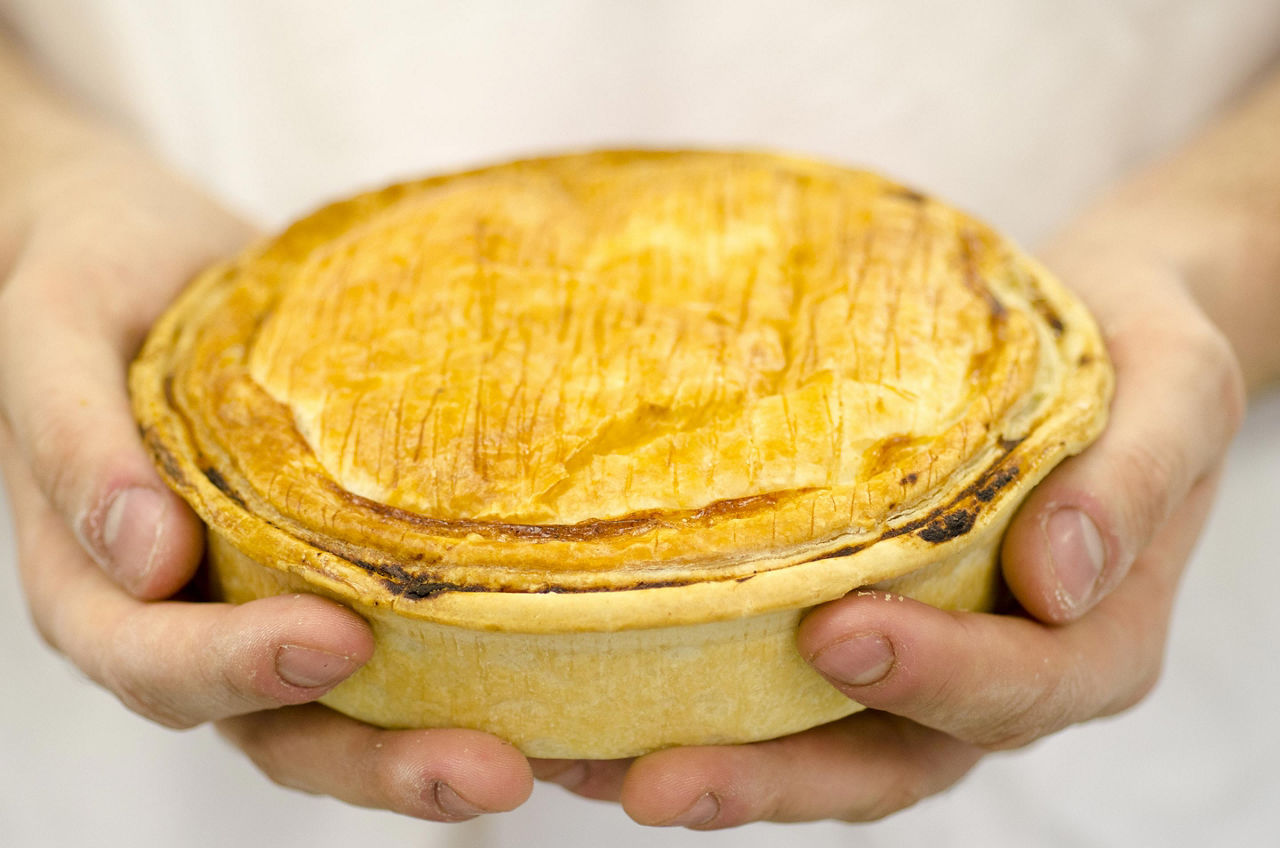 A chef holding a pie