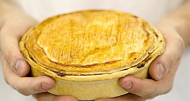 A chef holding a pie