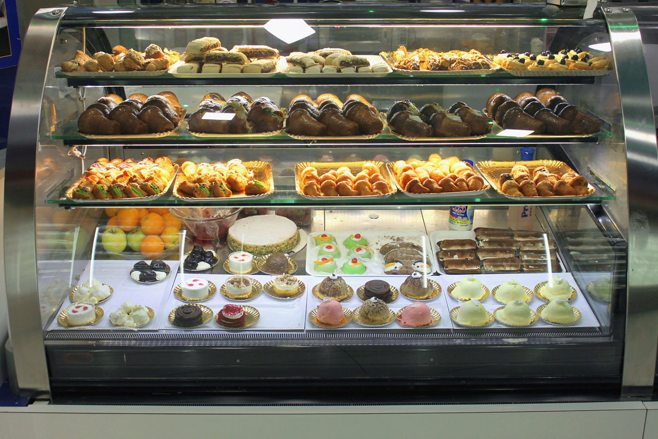 Italian pastry shop with different baba, donuts, jelly, ice cream, cakes with fruits and berries