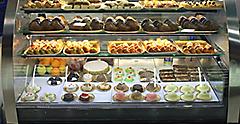 Italian pastry shop with different baba, donuts, jelly, ice cream, cakes with fruits and berries