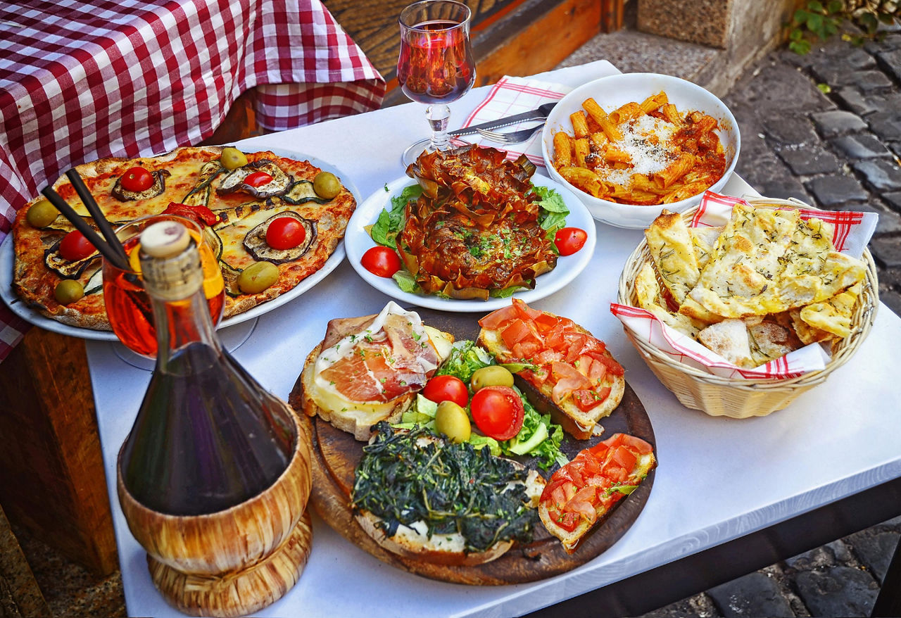 Pizza, pasta, and antipasta on a table in Rome