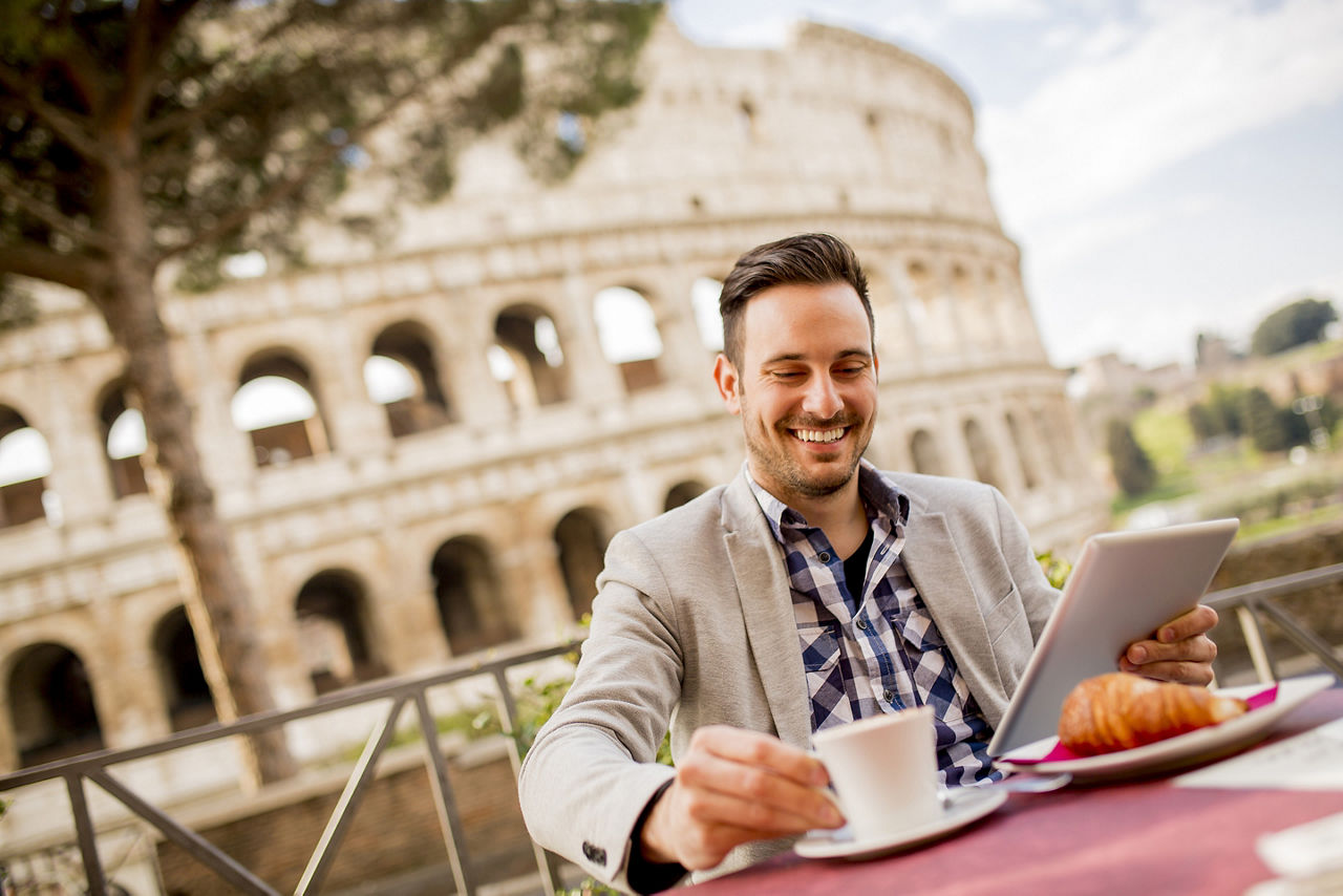 Young man sitting and having a cup of coffee in Rome, Italy