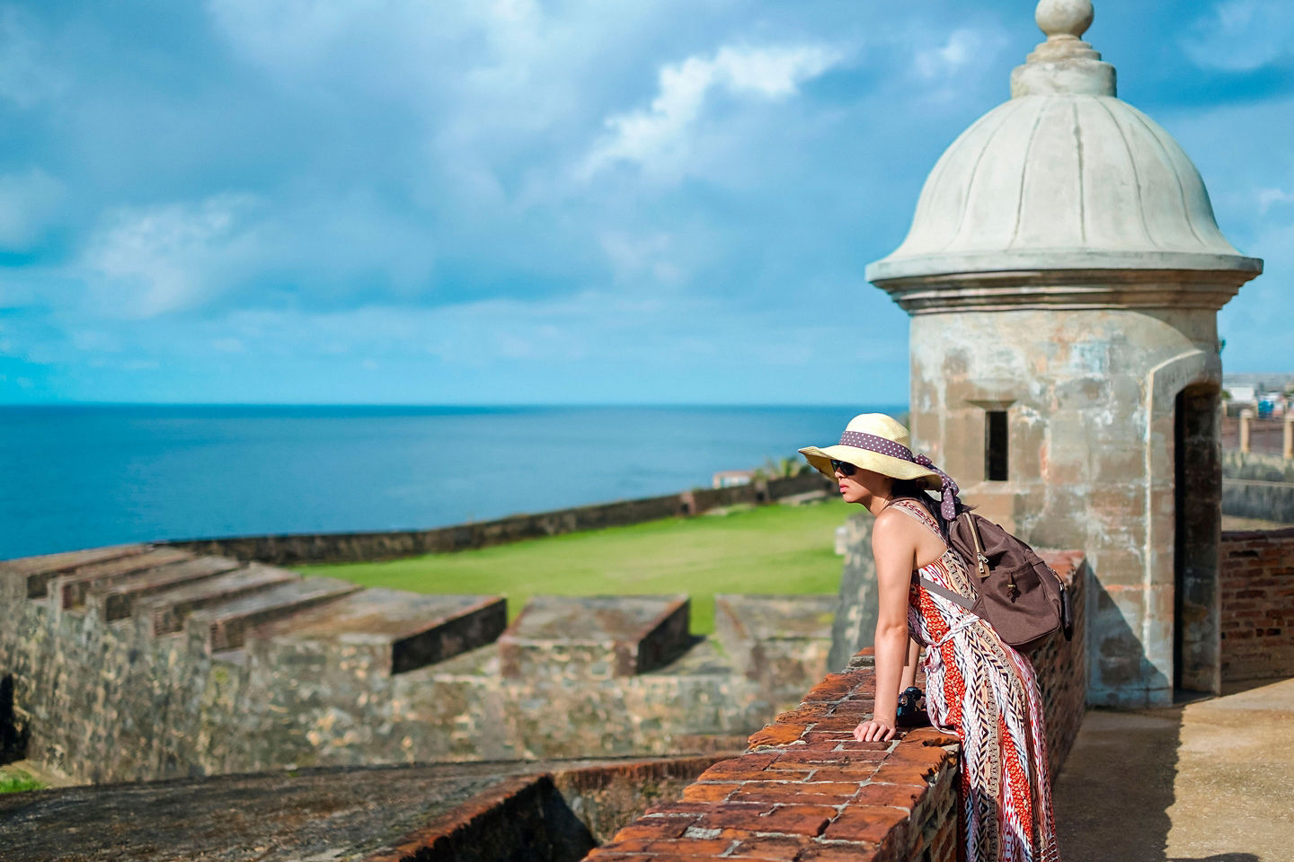 A woman overlooks El Morro’s oceanfront fort walls in San Juan, taking in sweeping coastal views. - San Juan, Puerto Rico