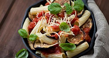 A bowl of pasta alla norma with eggplant and tomato