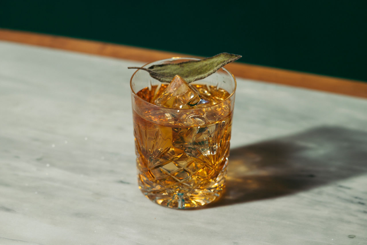 Amaro sour, a cocktail with Amaro Lucano, Luxardo or Averna; bourbon or whiskey; freshly squeezed lemon juice and simple syrup, garnished with sage