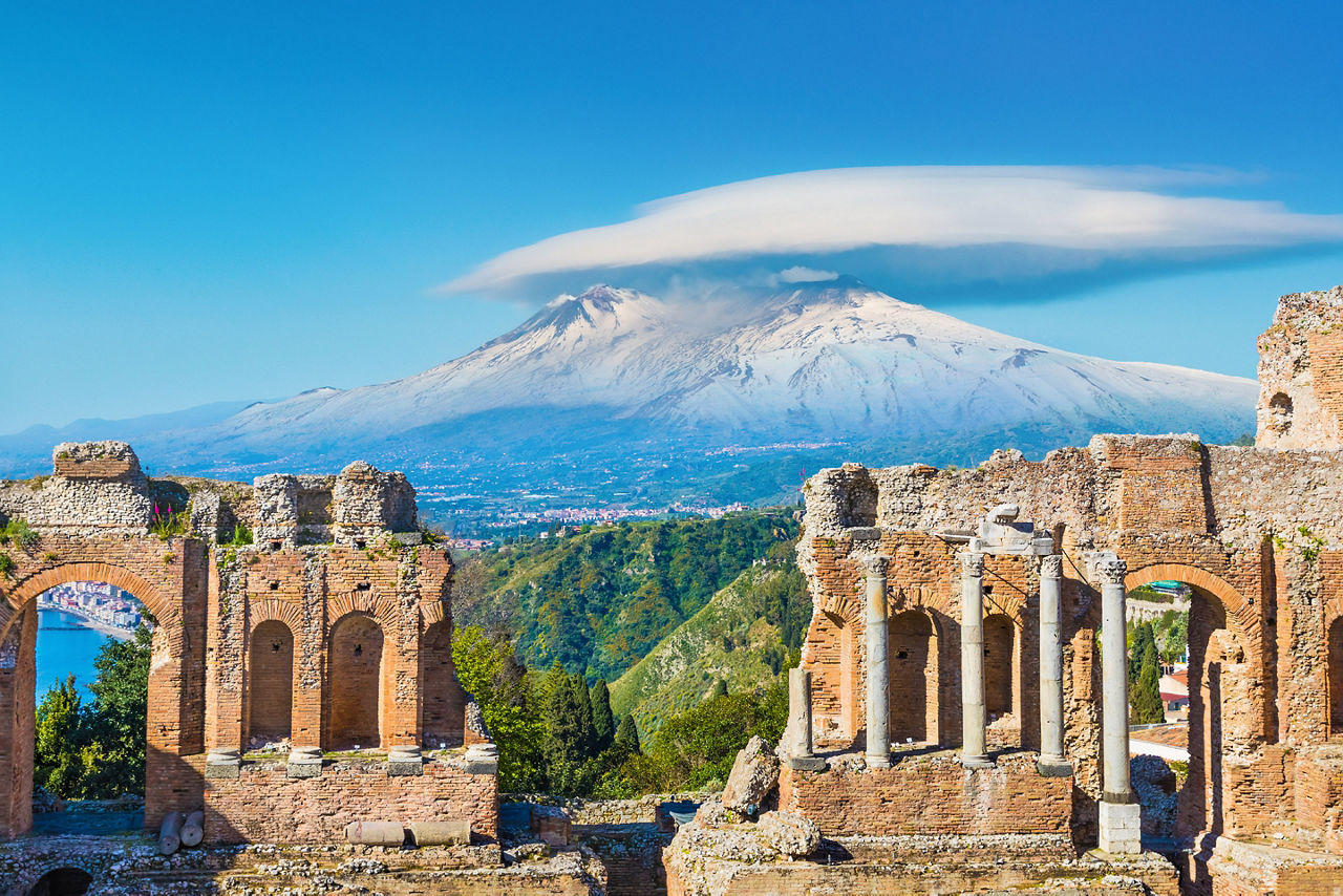 Ancient Greek theatre in Taormina on background of Etna Volcano, Sicily, Italy. 