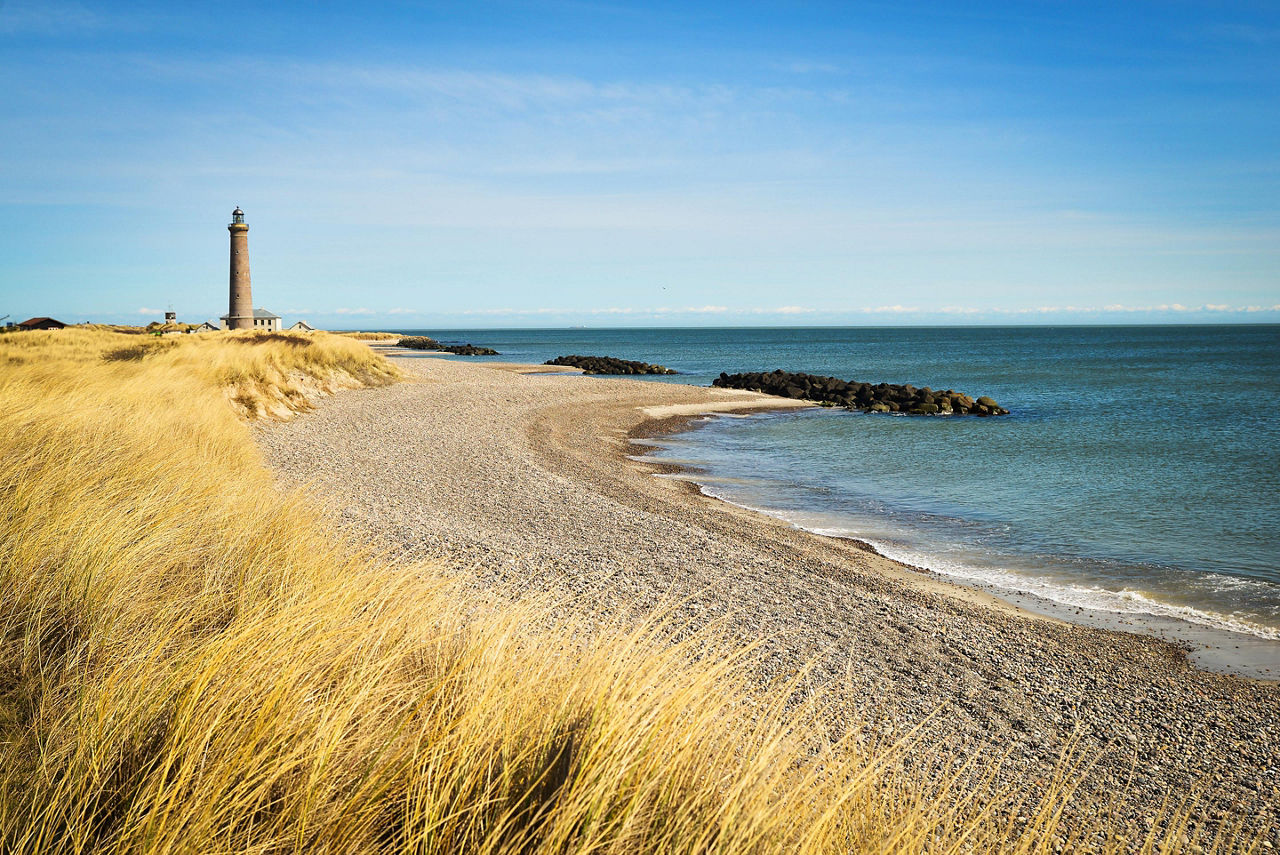 A beach in Skagen, Denmark with the Skagen Lighthouse in the distance