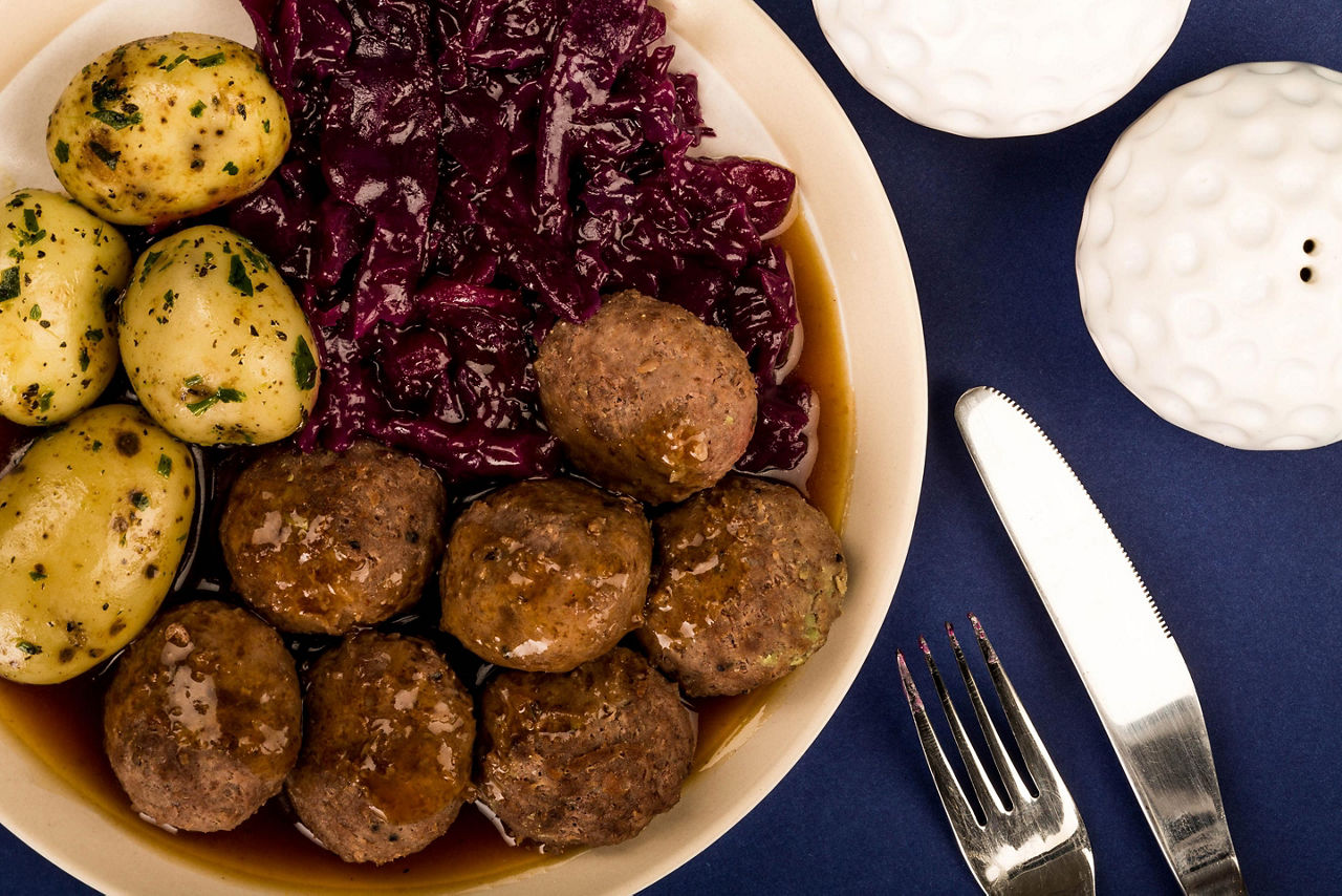 A plate with meatballs and boiled potatoes and cabbage