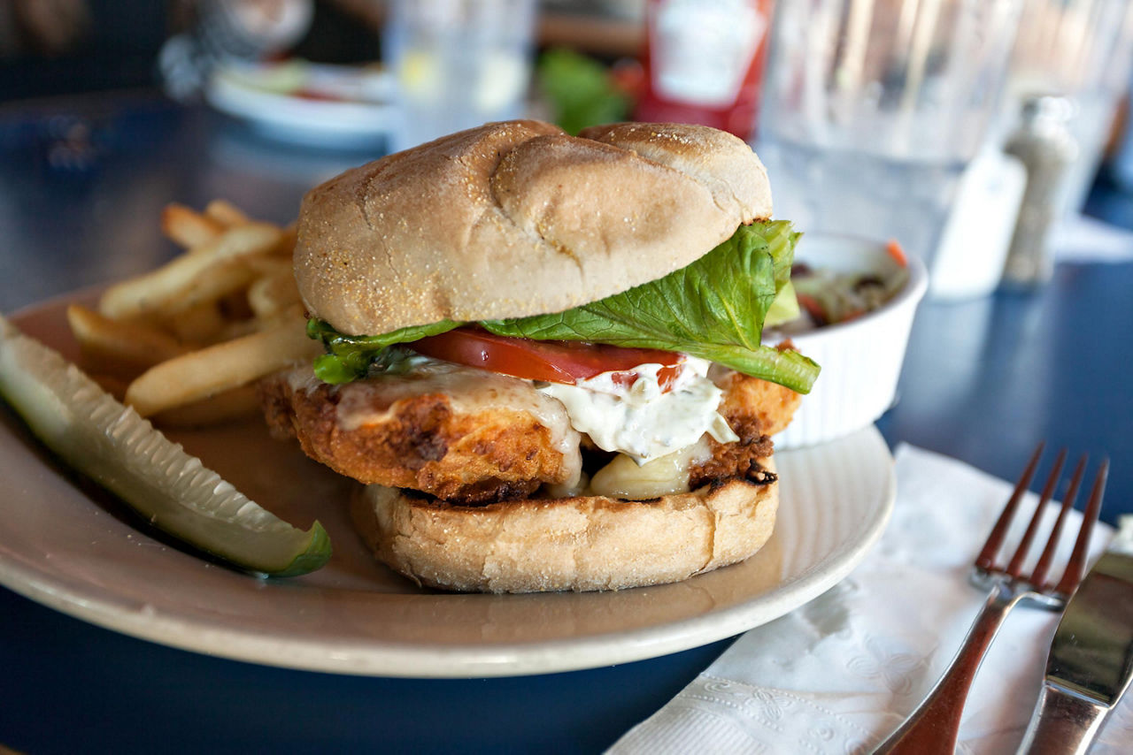 Fried fish sandwich with tartar sauce and french fries, on a restaurant in St. George's, Bermuda