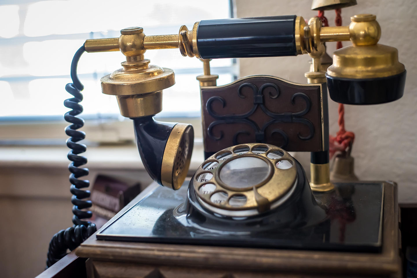 An antique wooden wall telephone with metal bells hangs at the Alexander Graham Bell Museum. - Sydney, Nova Scotia