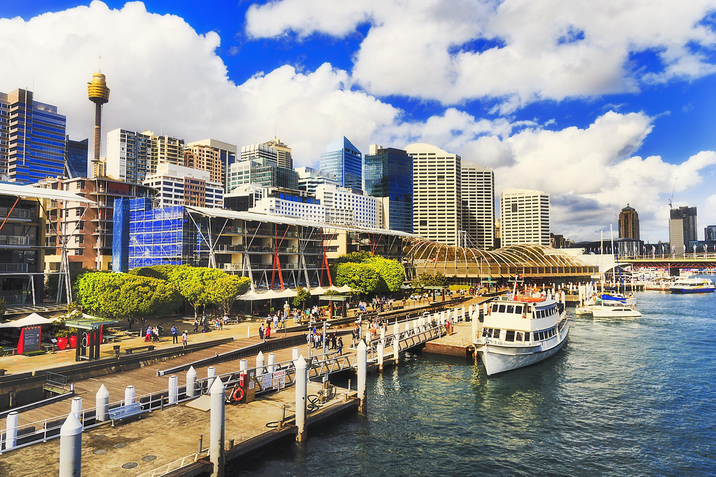 Darling Harbour waterfront with boats, modern buildings, and clear sky.