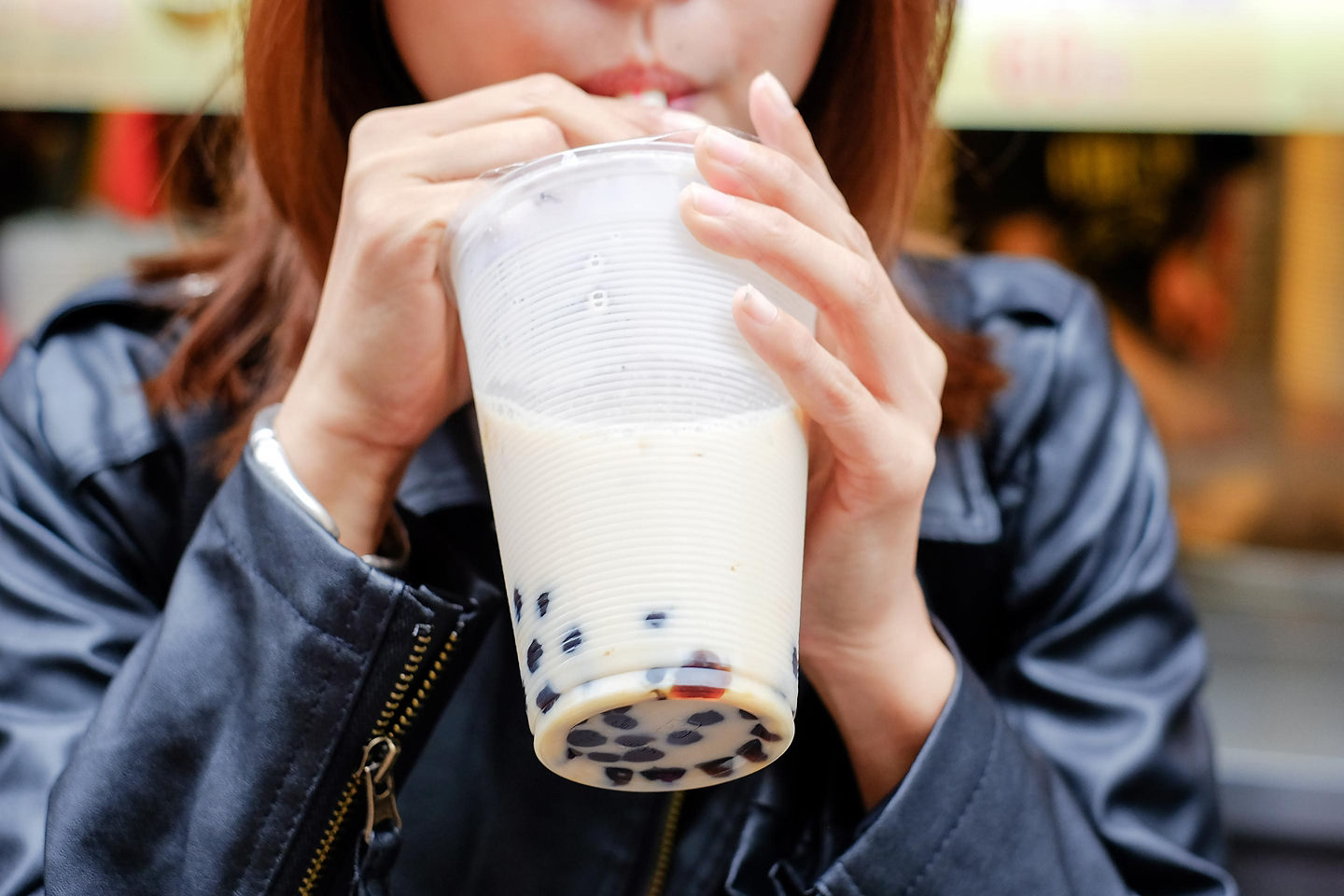 A woman enjoys pearl milk tea. - Taipei