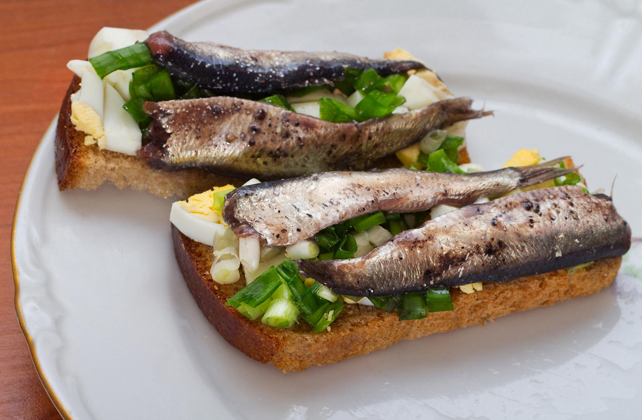 A herring sandwich on a white plate