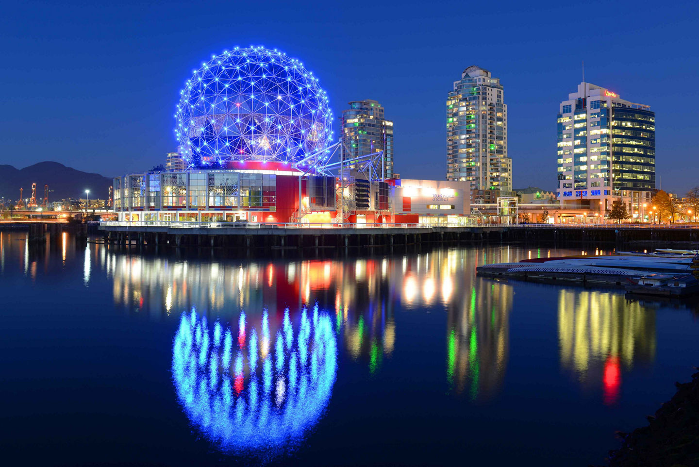 Science World glows over False Creek, reflecting vibrant colors across Vancouver’s waterfront. - Vancouver, British Columbia