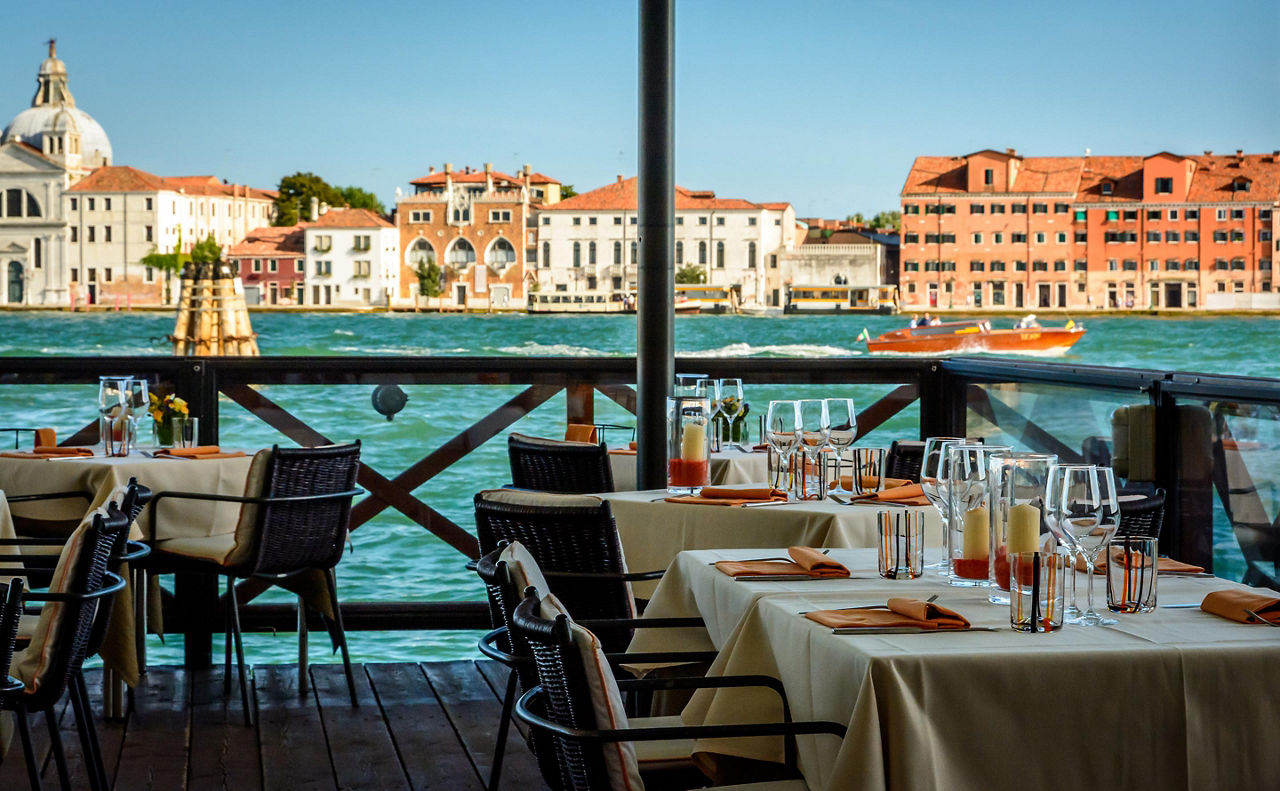 Tables set up at a waterfront café in Venice, Italy