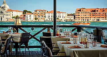 Tables set up at a waterfront café in Venice, Italy