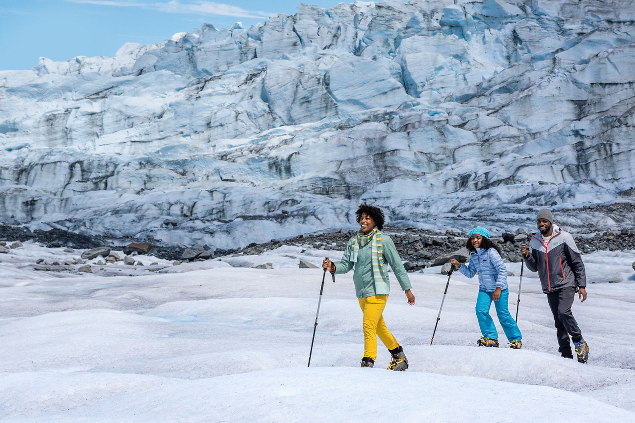 Family hiking Mendenhall Glacier in Alaska,