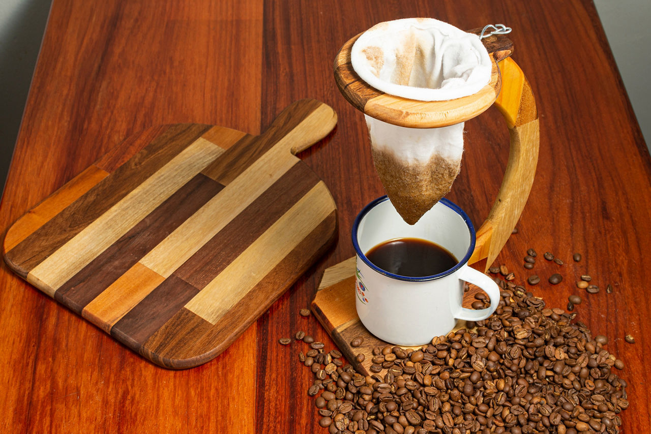 Wooden drip coffee machine with beans and cutting board. Costa Rica.
