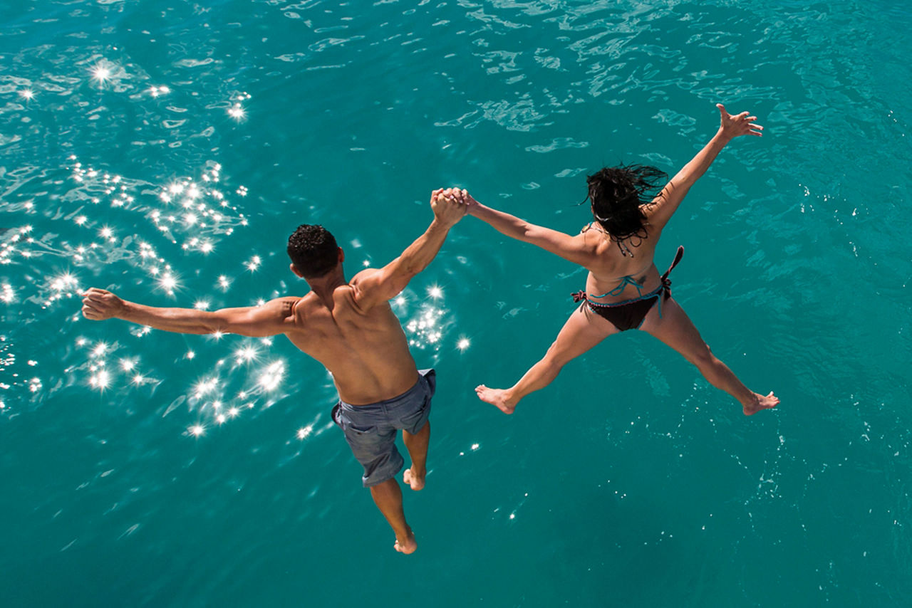 Couple Jumping in the Water in the Caribbean 