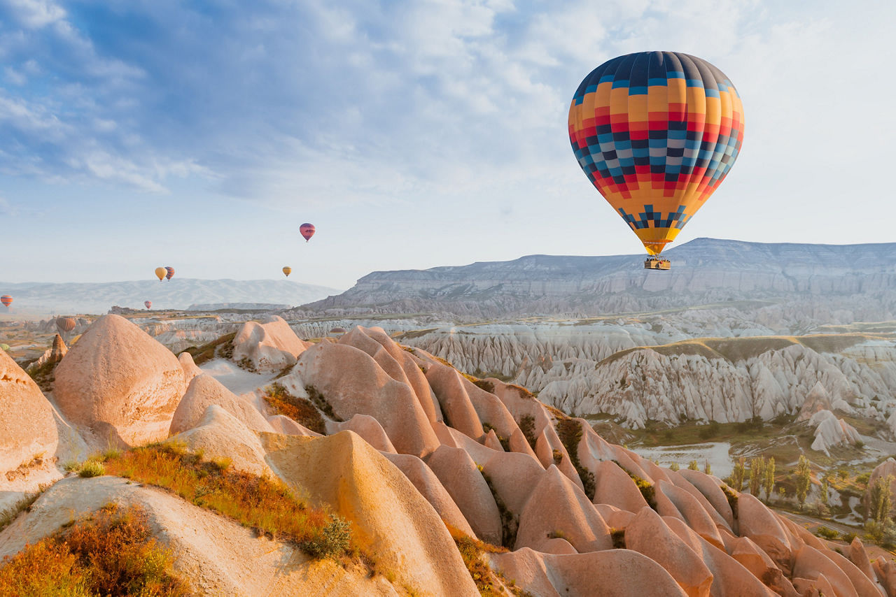 Cappadocia hot air balloon ride & tourist attraction above mountains. Turkey.
