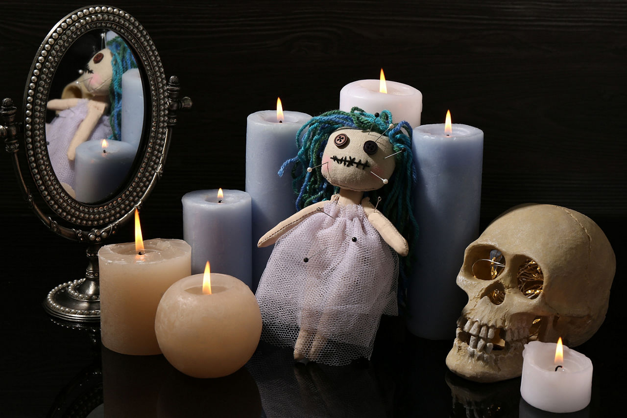 Voodoo doll pierced with pins and candles