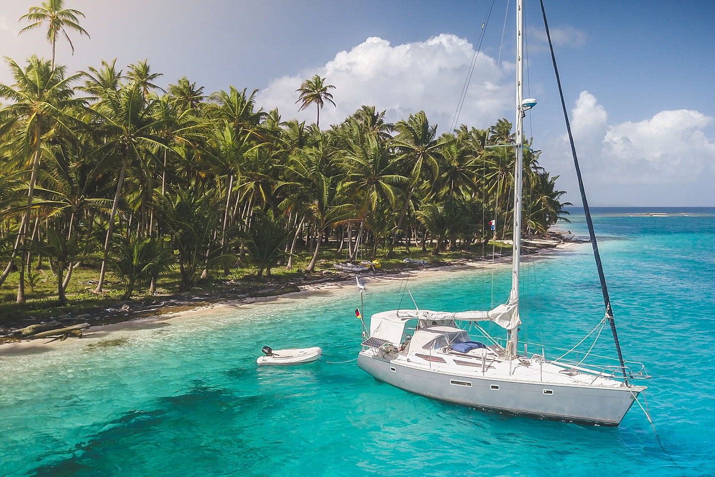 Anchored yacht drifts beside turquoise San Blas waters. - Colón, Panama