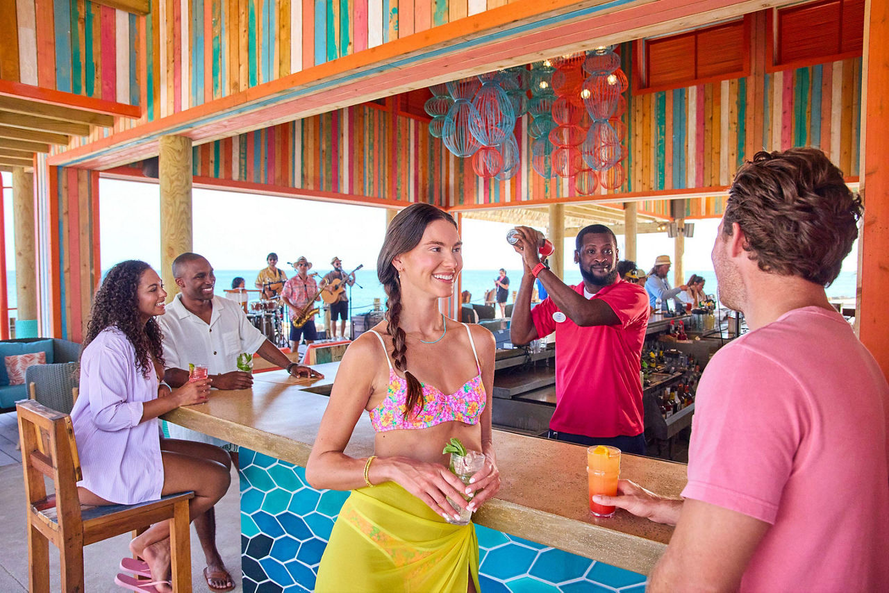 couple drinking and bar tender mixing cocktails