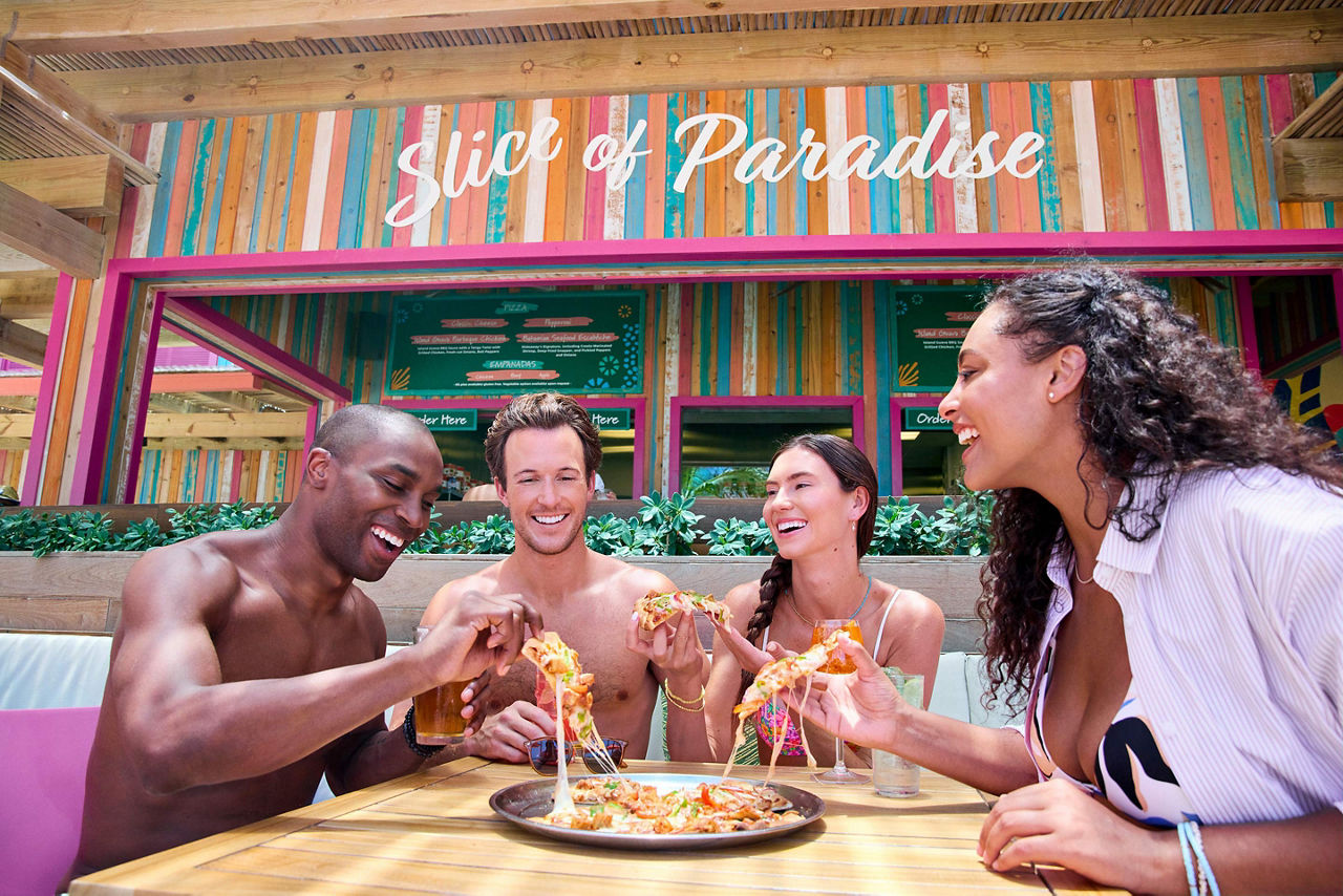 Friends enjoying a loaded pizza