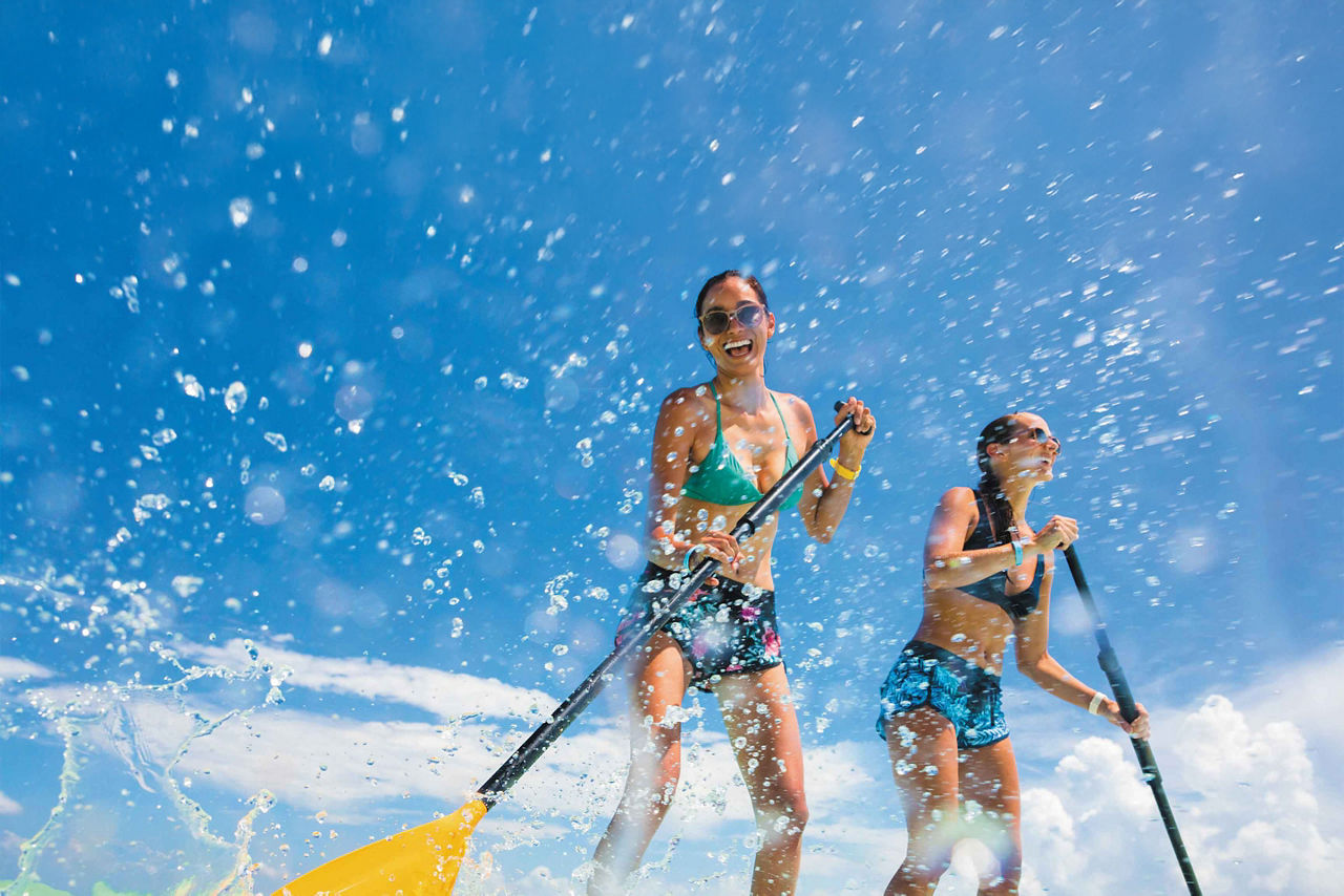 Two Girls Having Fun Paddle-boarding, Cozumel, Mexico