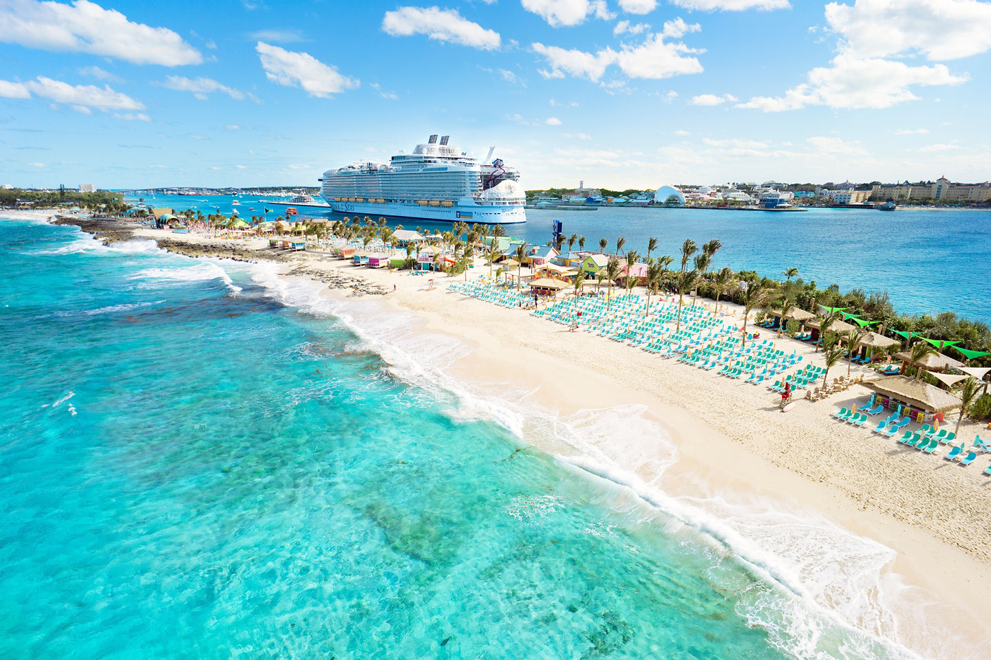 Aerial view shows Chill Beach’s wide shoreline, calm turquoise water, and a cruise ship offshore. - Nassau