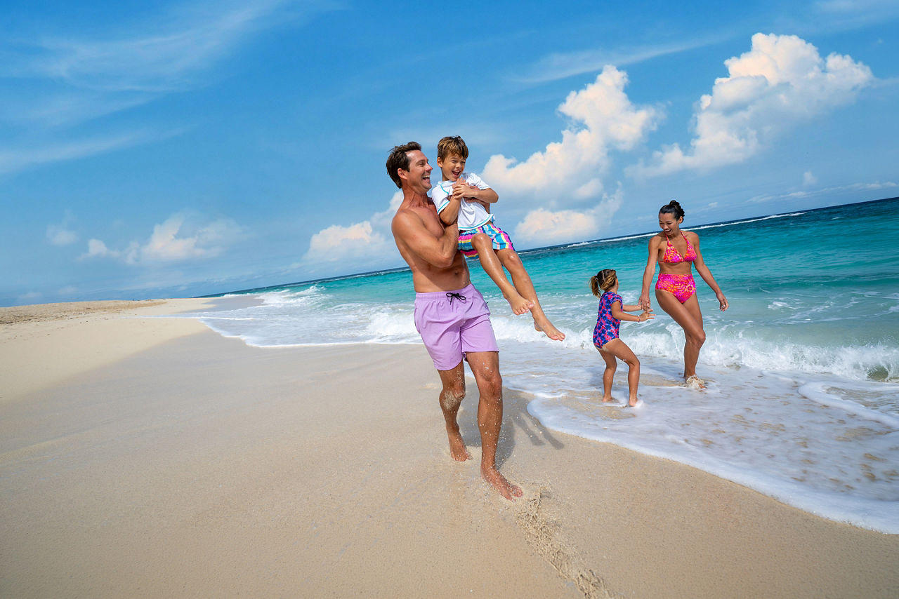Family playing soccer on the beach at Chill Beach at Royal Beach Club Paradise Island