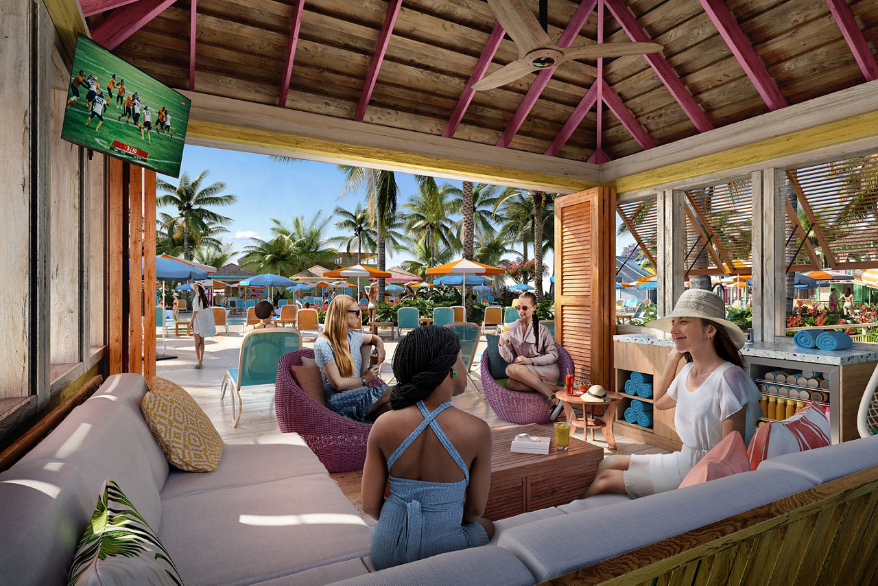 4 women sitting down chatting while enjoying drinks inside the premium pool cabana