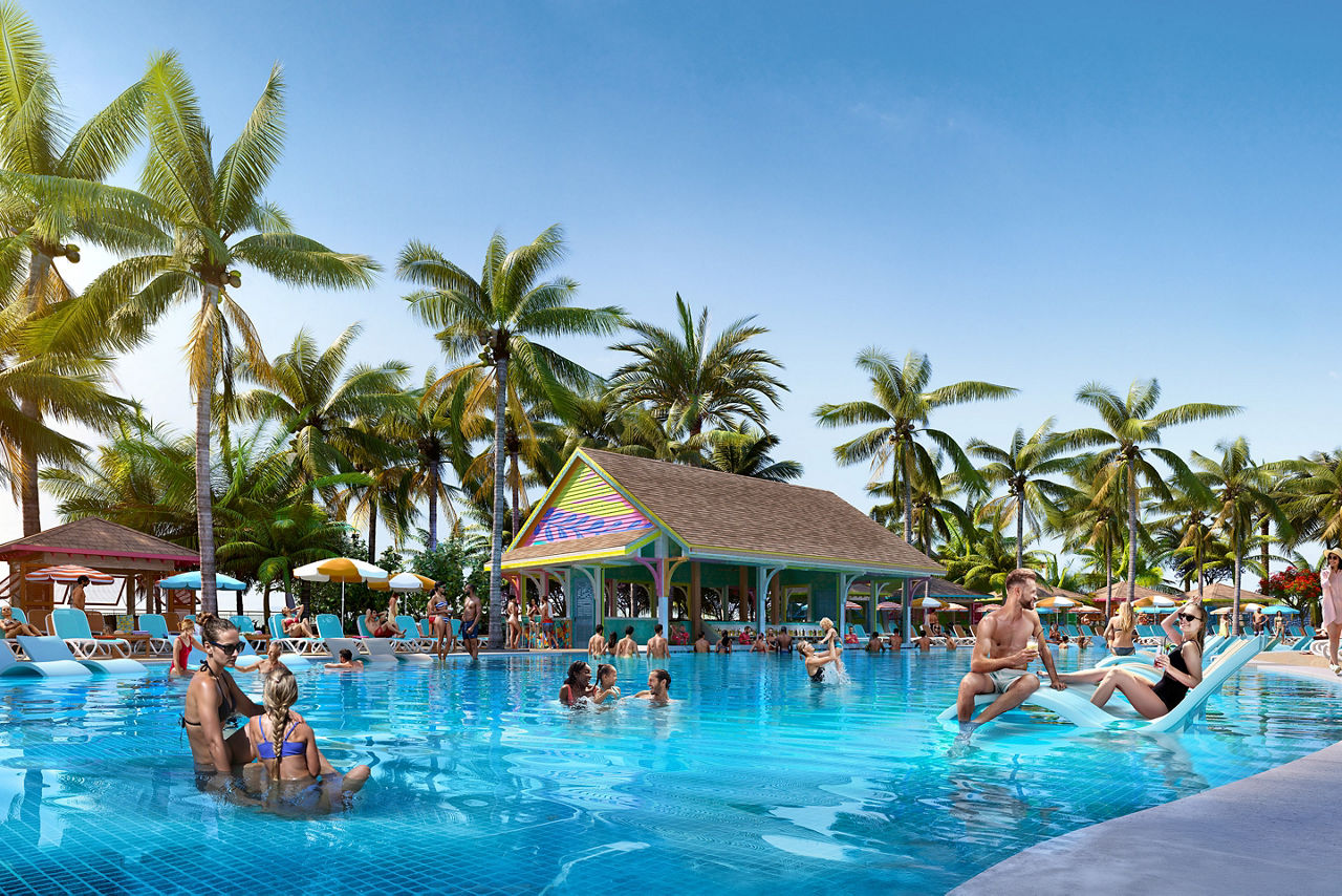 Pool side area lined with palm trees, filled with families enjoying the pool area