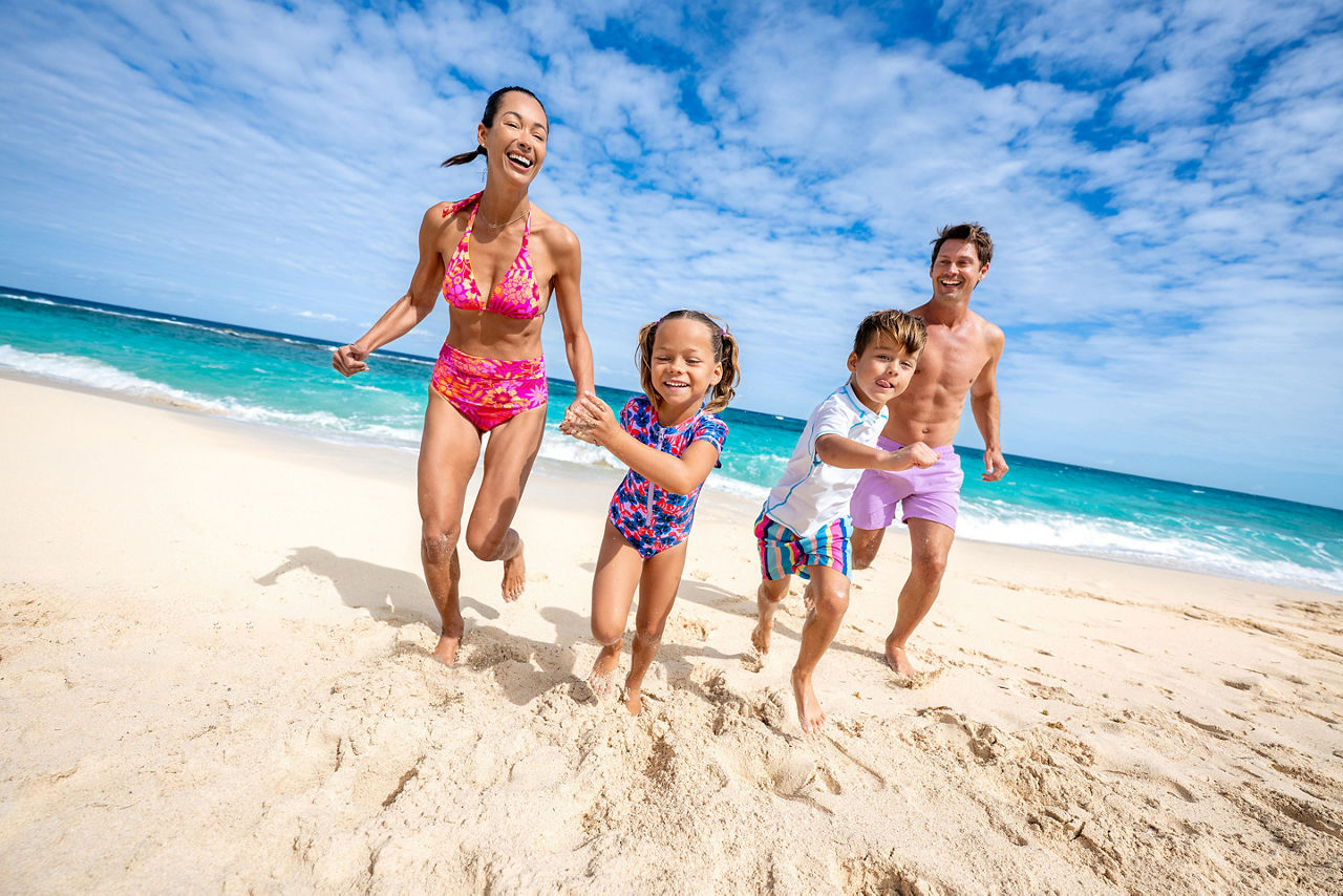 Famiy running along Chill Beach at Royal Beach Club Paradise Island.