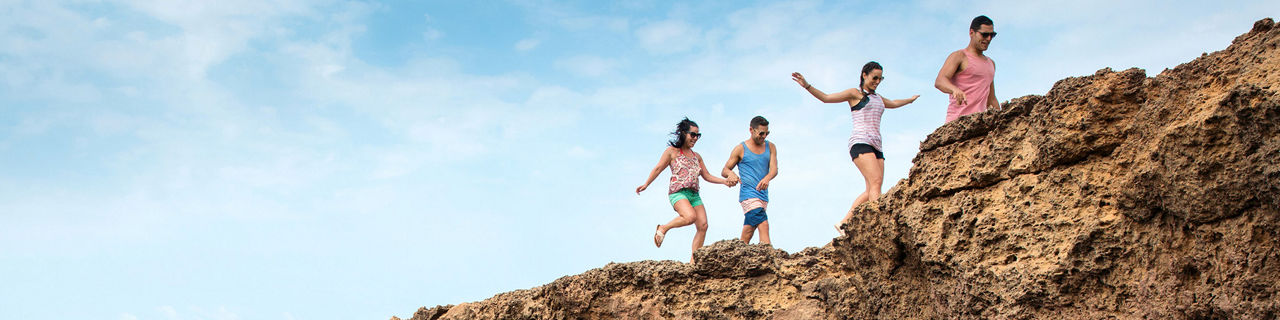 Family Jumping Through Rocks, Oranjestad, Aruba