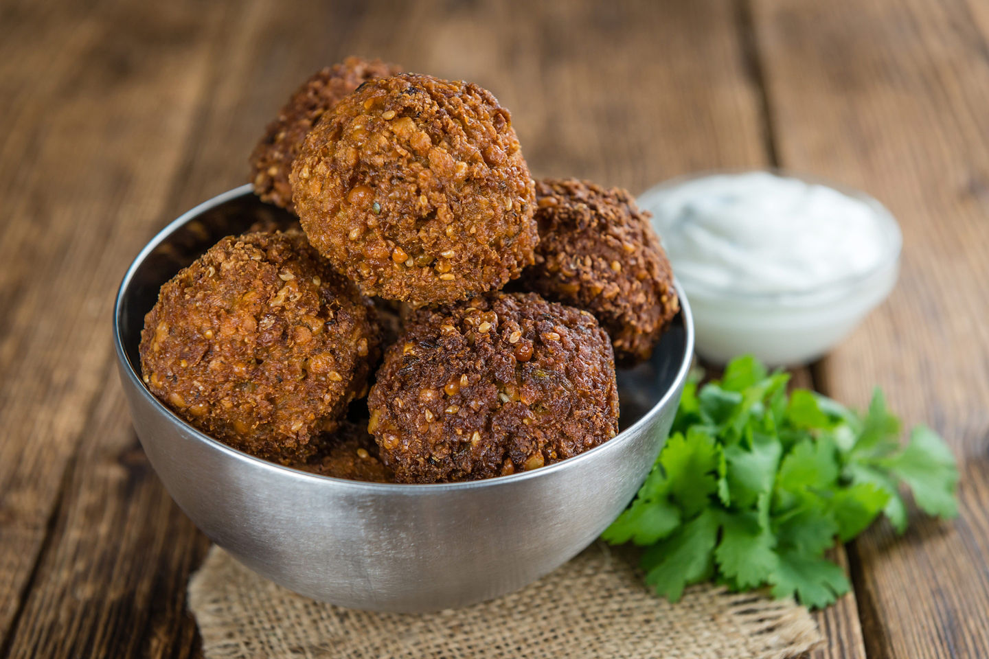 Falafel is served crisp and golden, topped with herbs and fresh vegetables. - Egypt