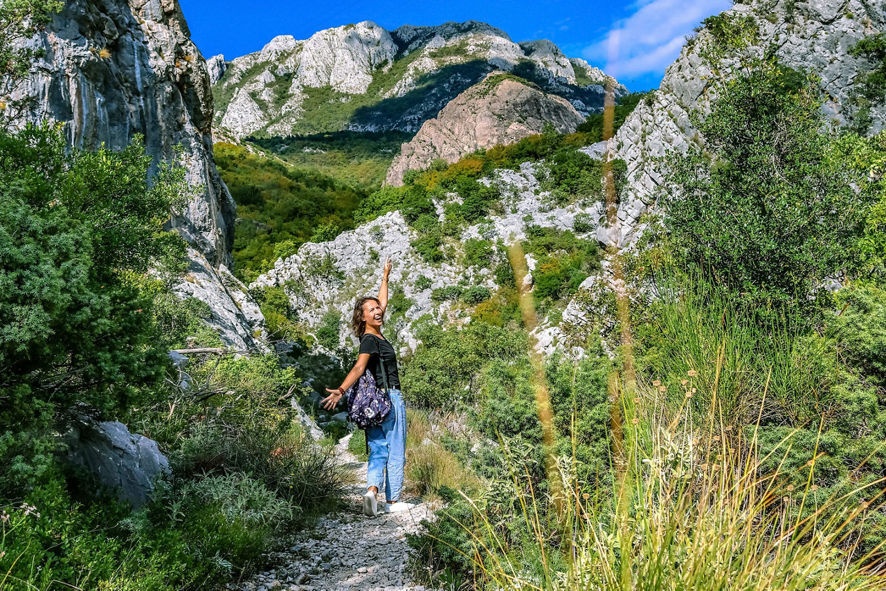 Happy tourist walks in the mountains. Suburbs of the city of Bar, Montenegro, Balkans.