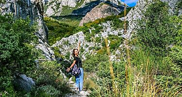 Happy tourist walks in the mountains. Suburbs of the city of Bar, Montenegro, Balkans.