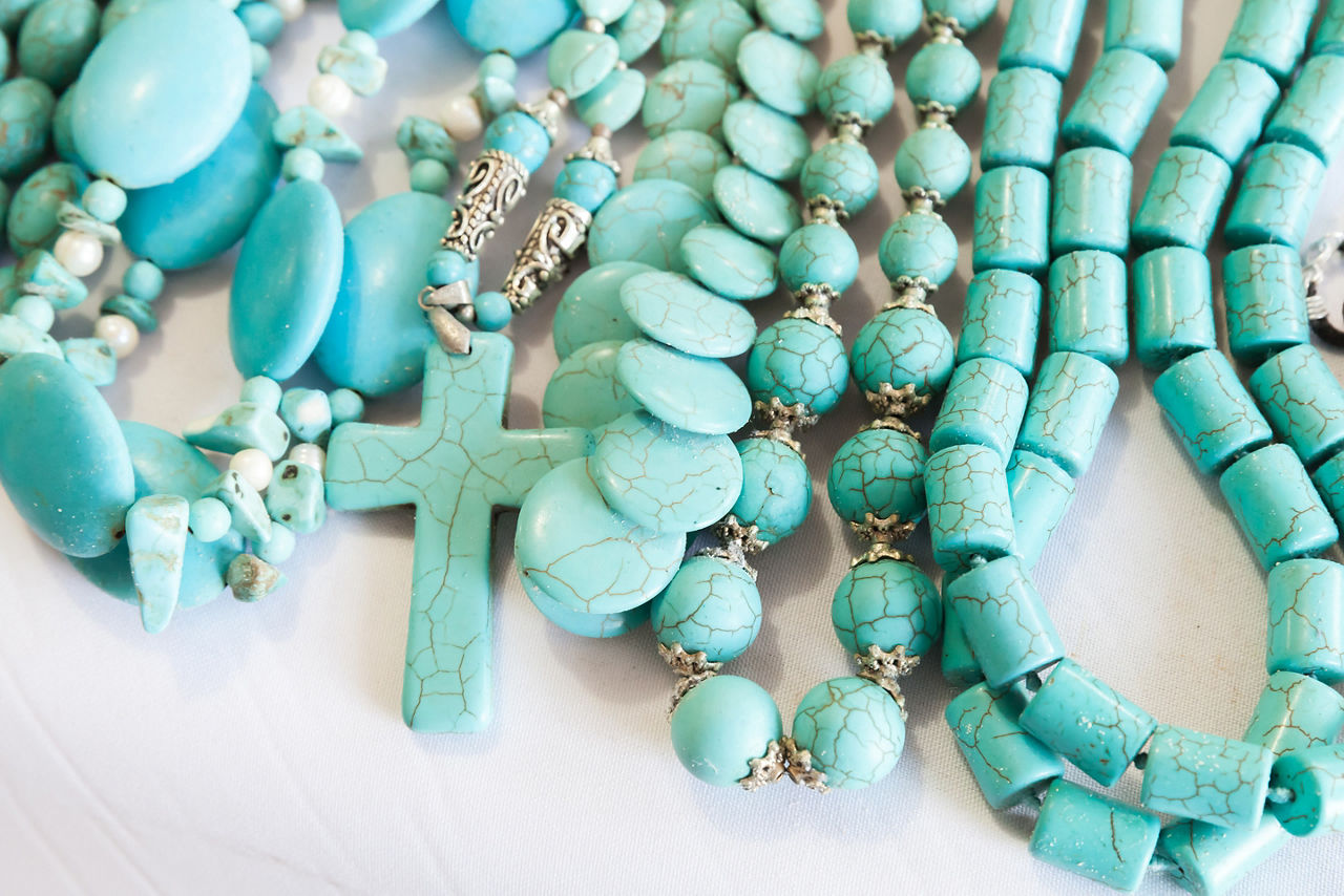 Beads of blue turquoise stone lie on the counter of souvenir shop on the beach in Dominican republic