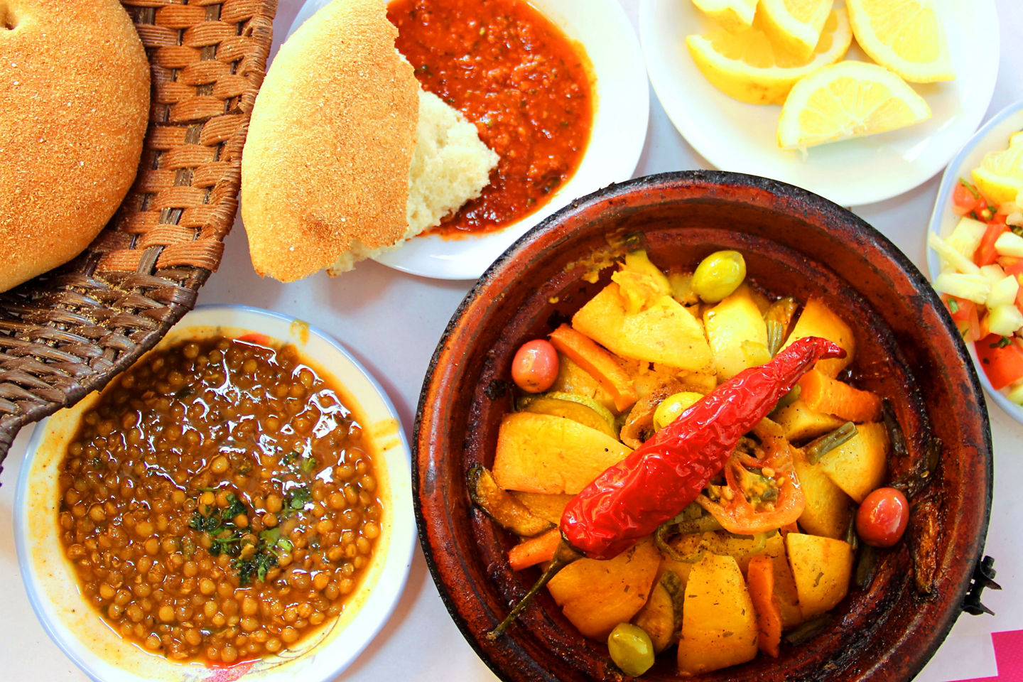 A Moroccan tagine simmers with vegetables and spices, served in a traditional clay pot. - Morocco