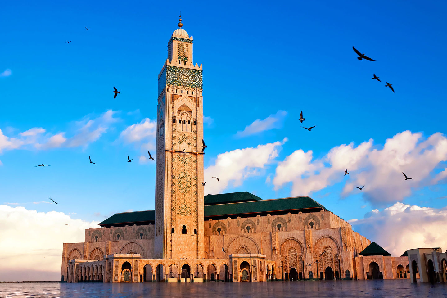 Close-up of the Hassan II Mosque shows ornate arches and detailed stonework in bright daylight. - Casablanca, Morocco
