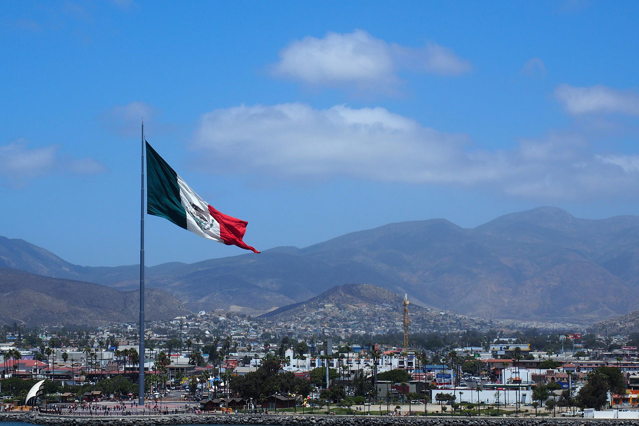 Harbor city in Ensenada with a Mexican giant waving flag. Mexico.