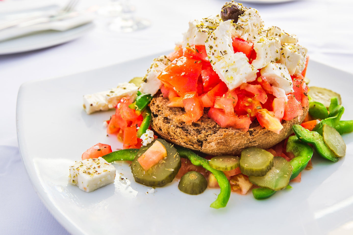 Dakos, Crete’s signature meze, combines tomatoes, mizithra cheese, and olive oil on barley rusks. - Chania (Souda), Crete