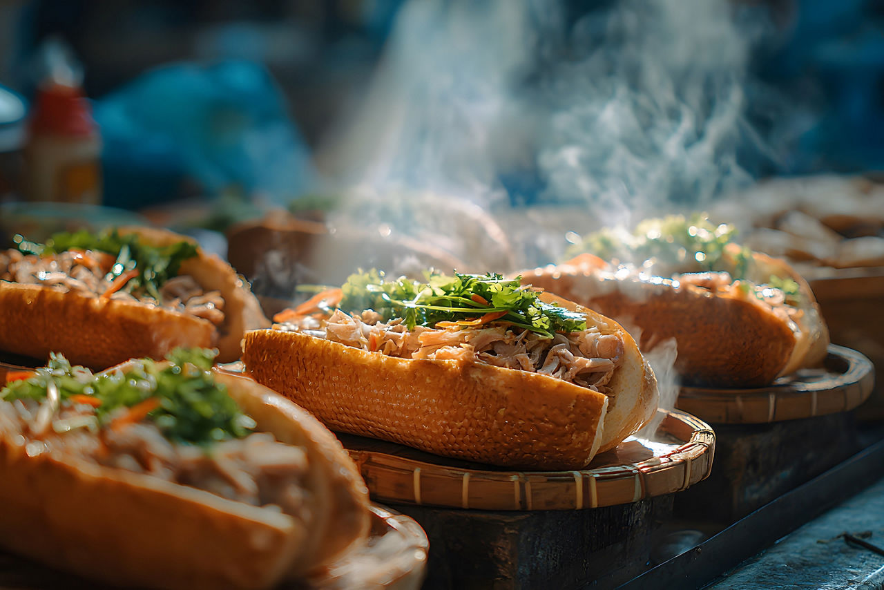 Fresh bánh mì sandwiches are served hot with traditional Vietnamese ingredients at a local street food stall.