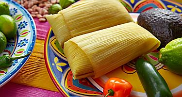 Two corn tamales on a colorful plate
