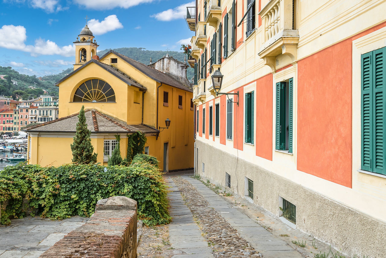Narrow street between colorful buildings at the port of Santa Margherita, Ligure, Italy.