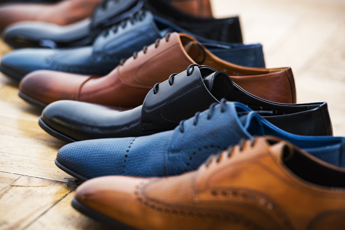 Men’s leather shoes are neatly arranged on shelves, showing varied styles and polished craftsmanship. - Santa Margherita, Italy