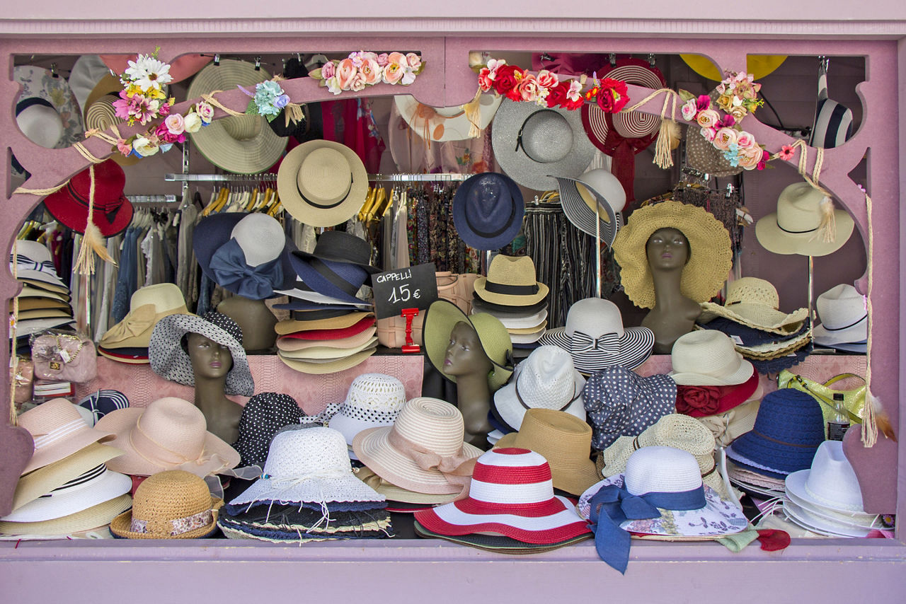 Open market stall with summer straw hats in Trieste, Italy